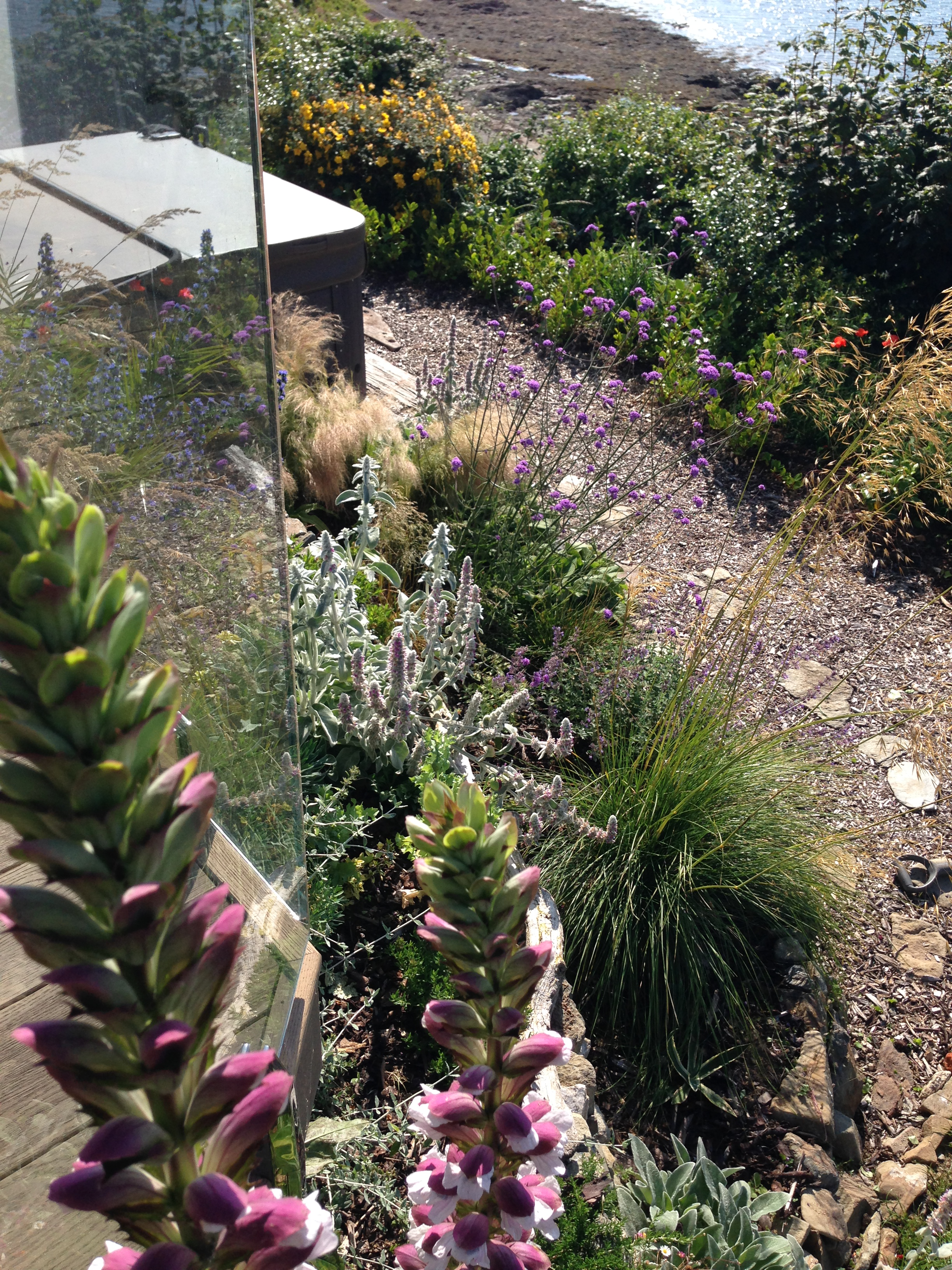 view of hot tub set within landscaped retaining walls enjoying views out to sea